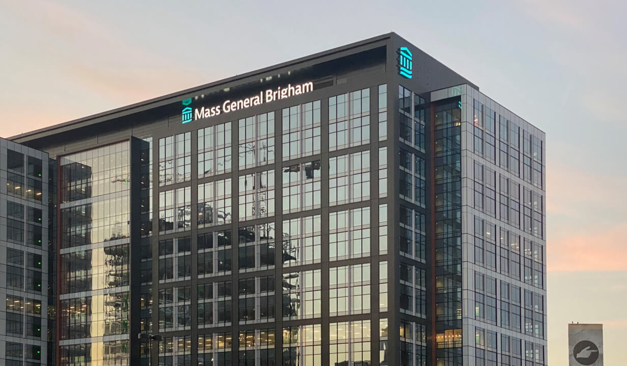 Exterior of the Mass General Brigham building at sunset.