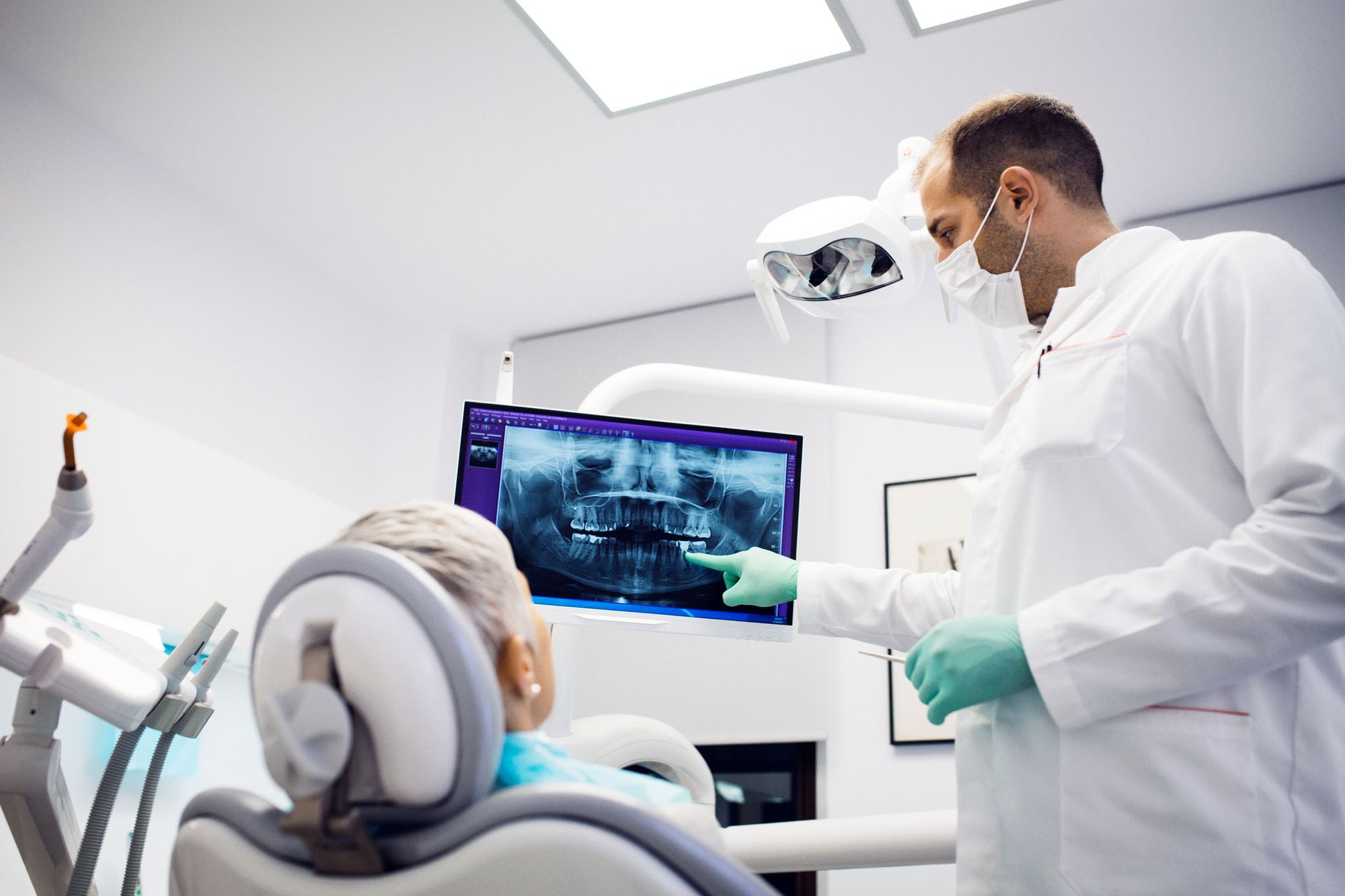 Dentist reviews xrays with dental patient sitting in chair