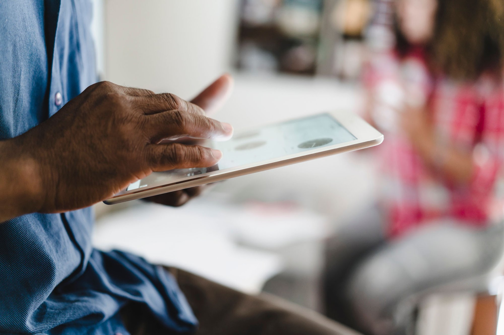 Mans hands using an ipad in soft focus