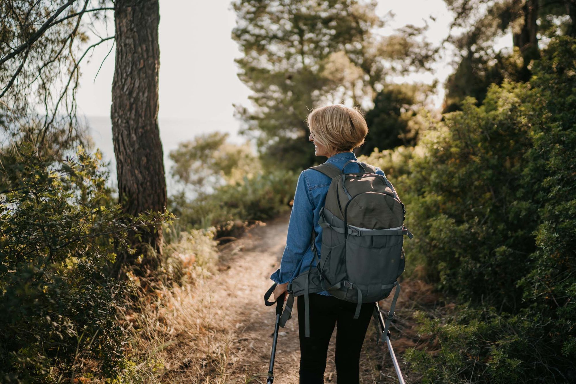 Woman hiking in sunlit forest