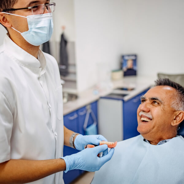 Dentist and patient laughing and discussing dentures.