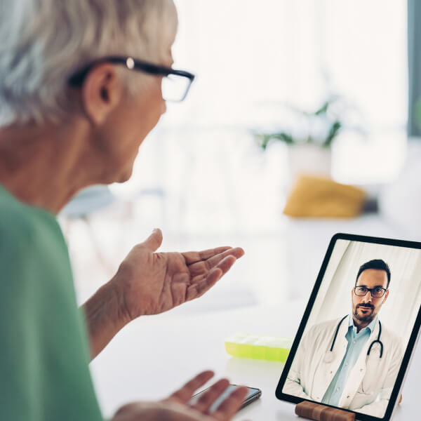 Woman talking to a doctor during a virtual consultation on her tablet.
